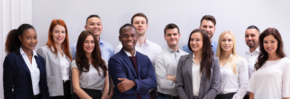 Group,Of,Young,Successful,Multi-ethnic,Businesspeople,Standing,In,Office,Looking